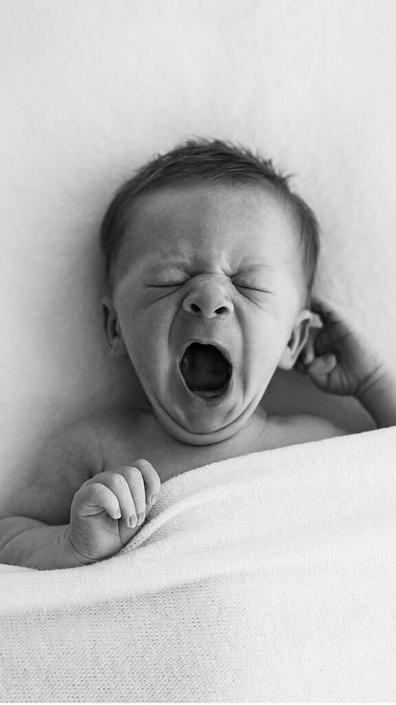 Newborn yawning, black and white photo