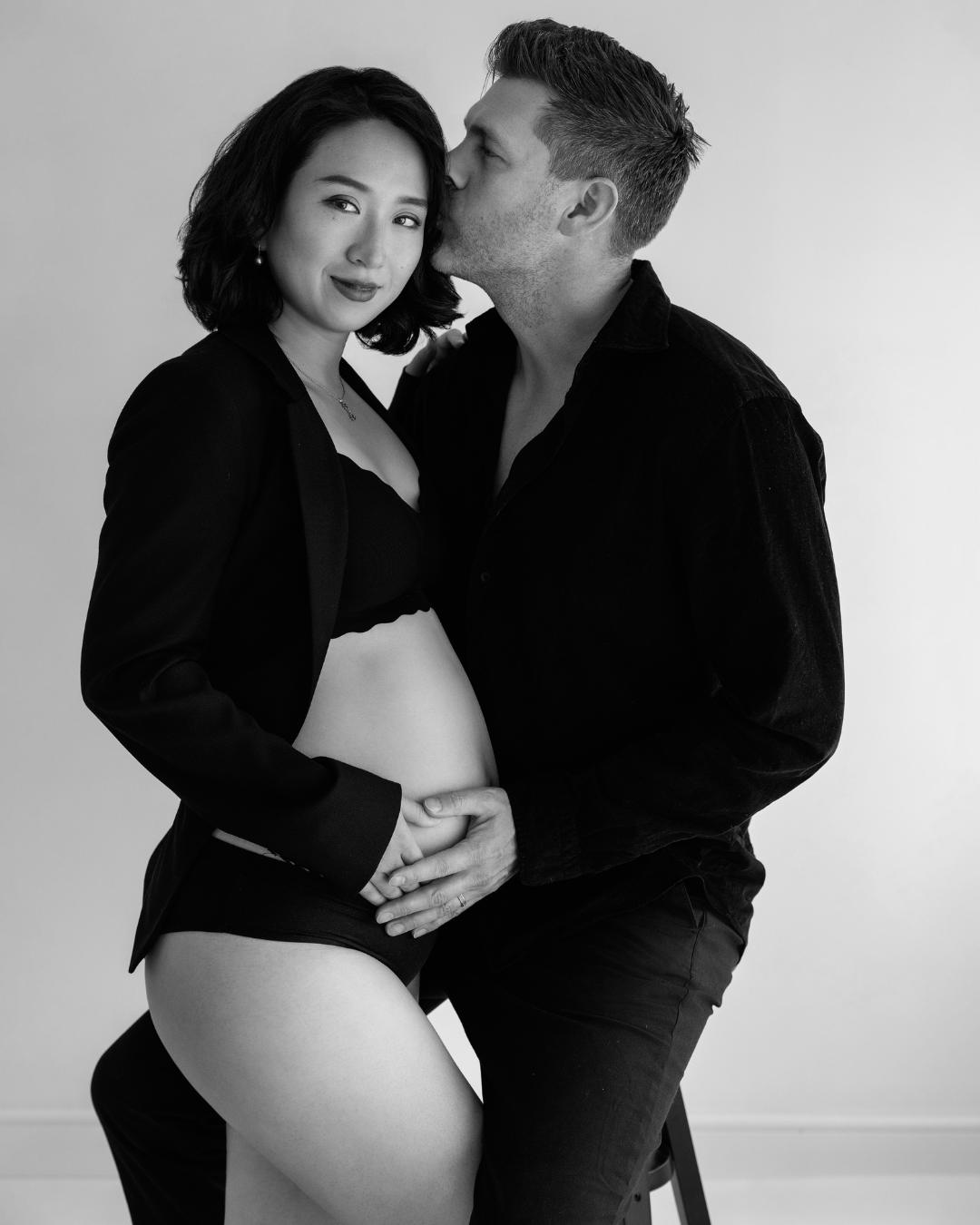 Black-and-white studio maternity portrait of an expecting couple, photographed by a London maternity photographer at Photography by Valentina.