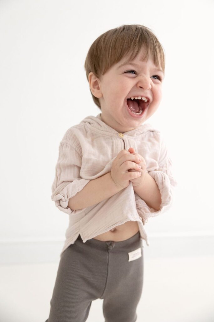 Smiling toddler laughing with joy — full of personality and playfulness typical of August babies.