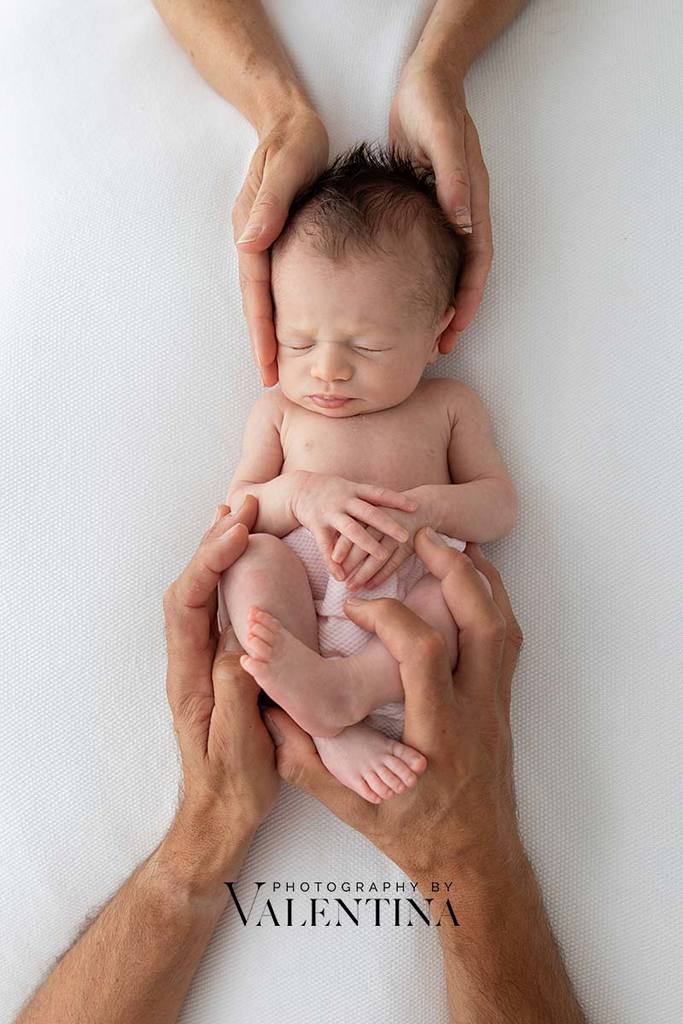 baby girl laying on her back and sleeping during her newborn session