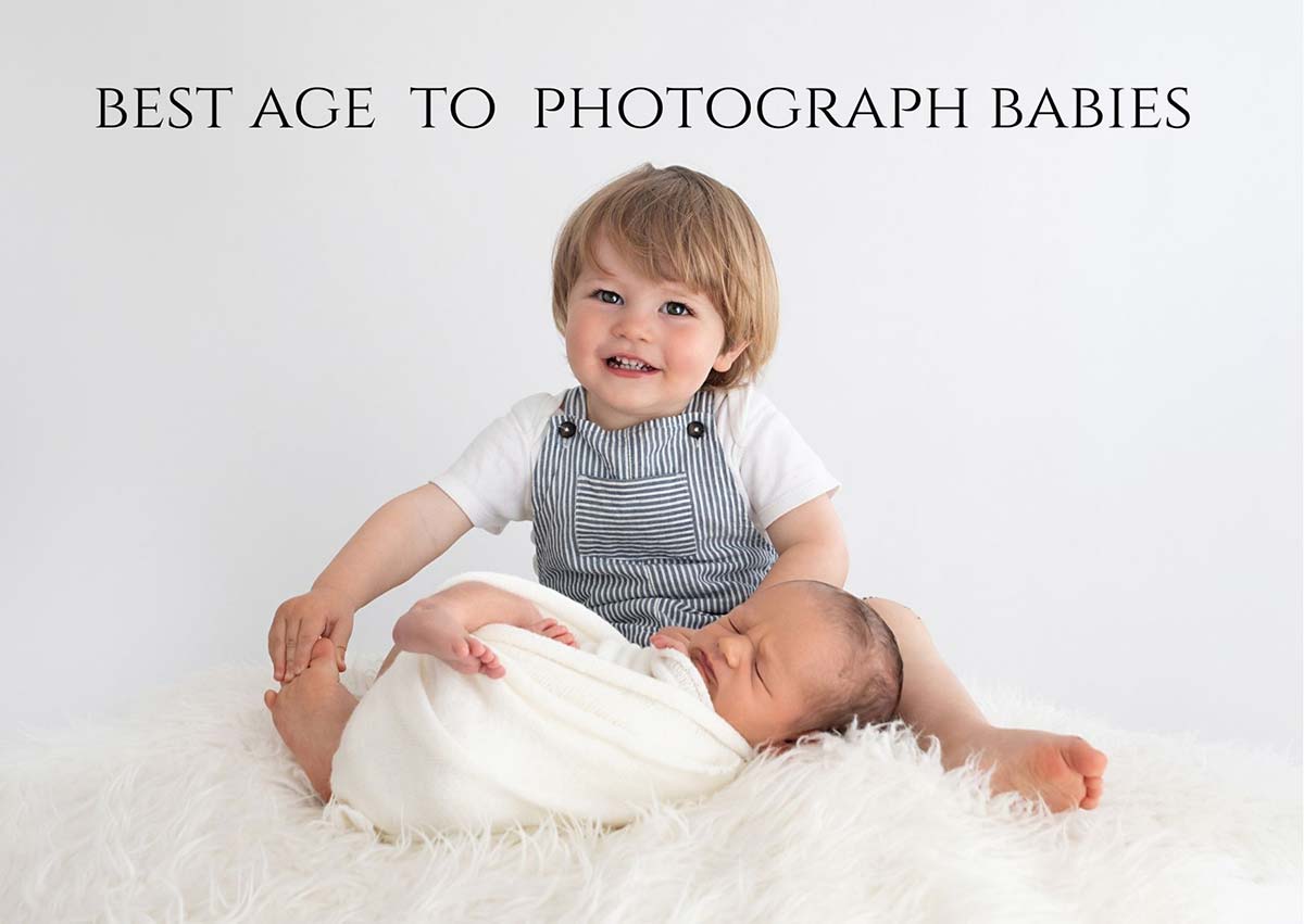 Toddler holding a newborn baby on a fluffy white background