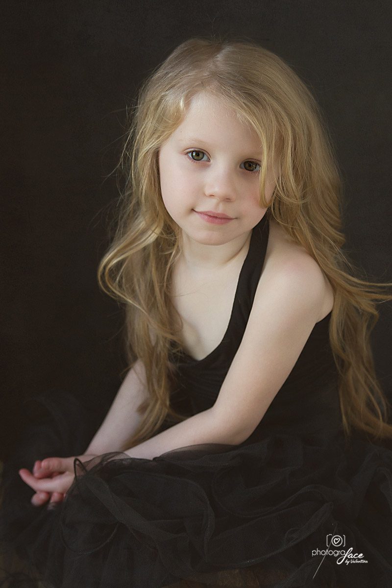 Children photographer London. Portrait of 5-year-old girl on a black background