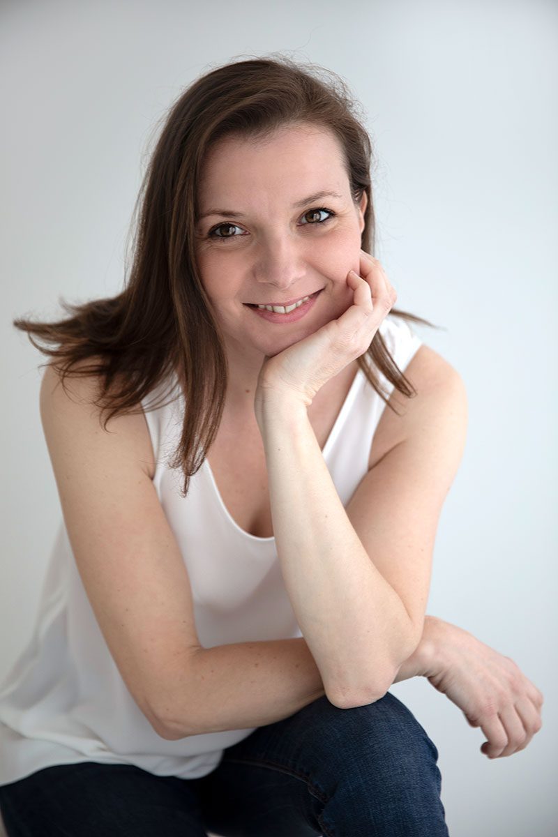 Valentina, London maternity and newborn photographer, smiling in white top – portrait used in contact section