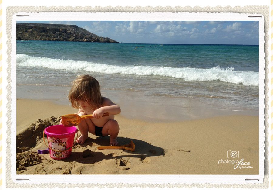 little girl playing with the sand at the beach