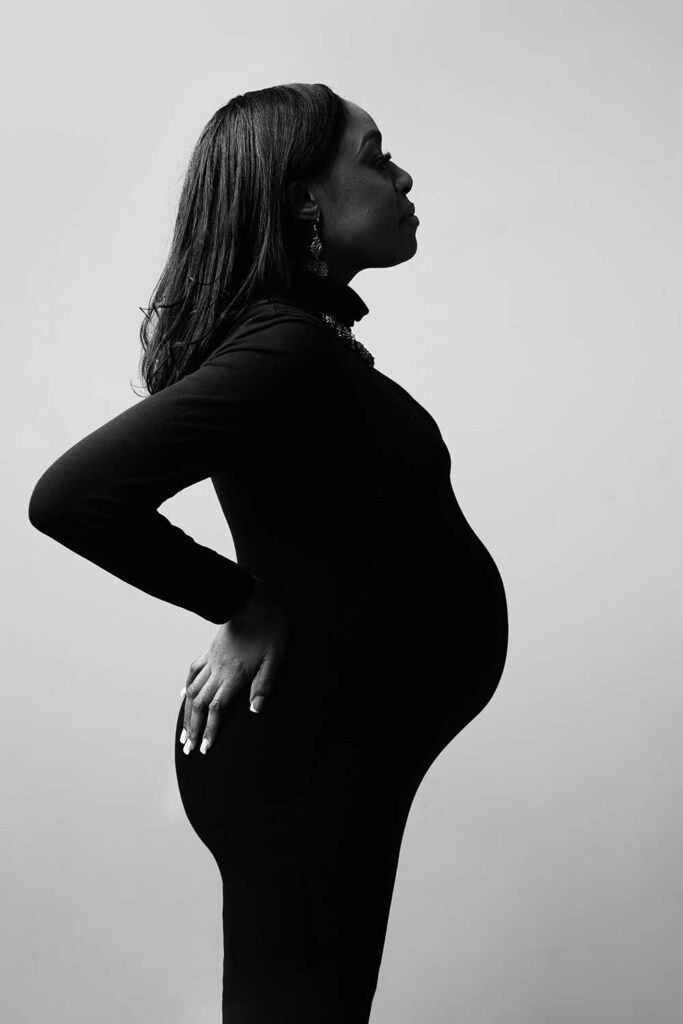 silhouette of pregnant woman wearing a black dress that shows the baby bump