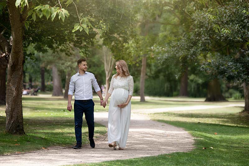 Coordinated outfits for maternity photos - couple in neutral tones during outdoor maternity photoshoot