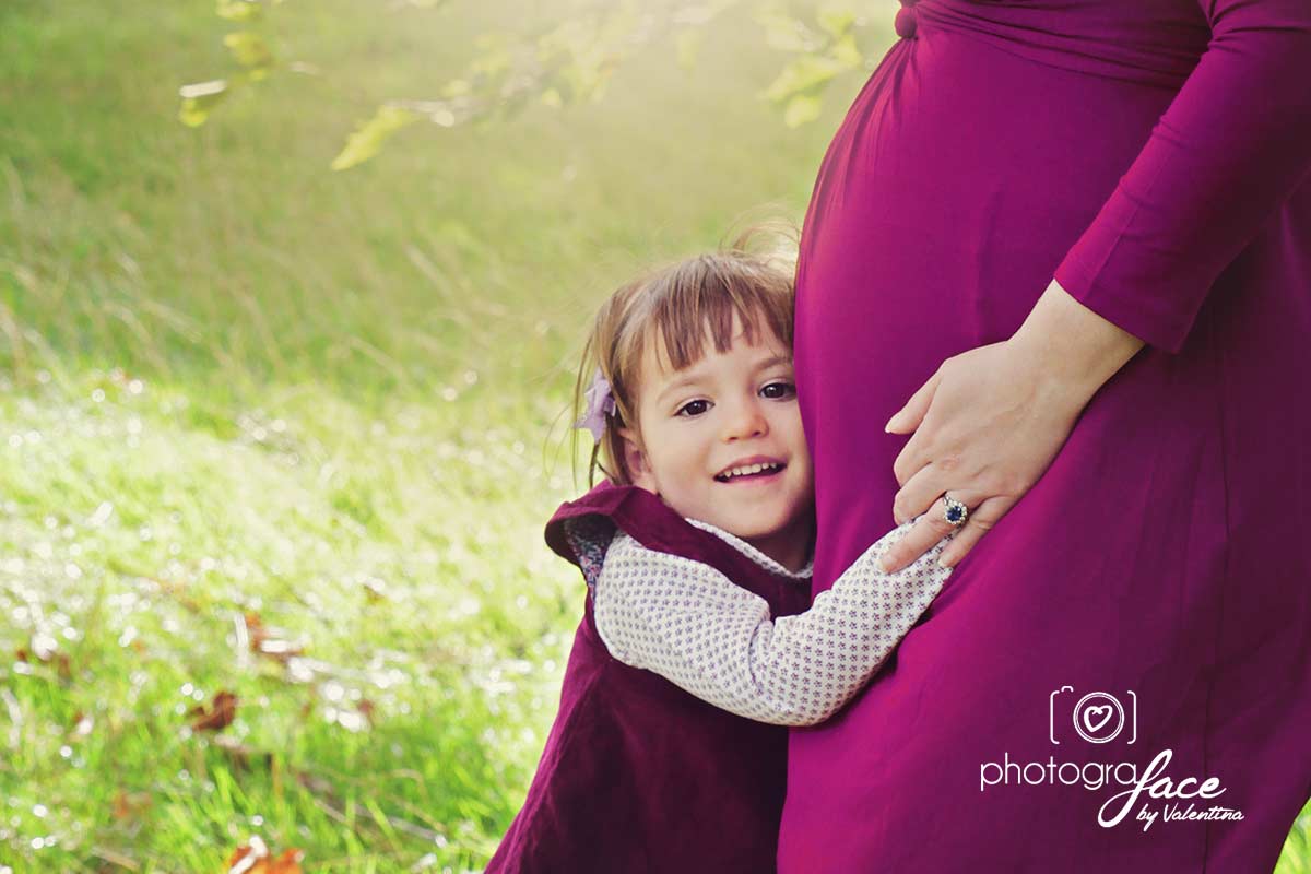 girl hugging mum's pregnant belly