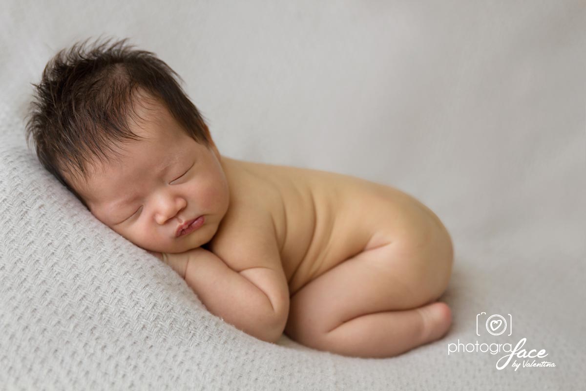 newborn posing naked in tummy pose during a photoshoot