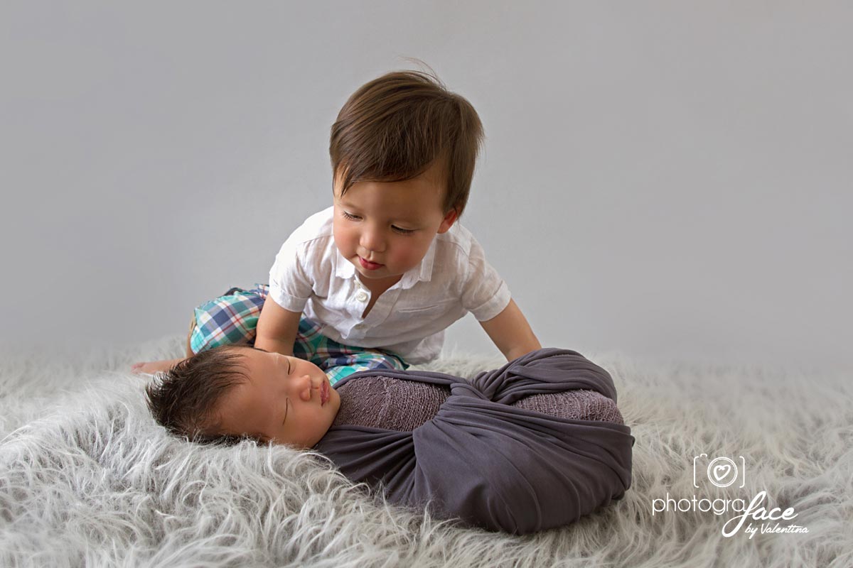 big brother kissing newborn sibling