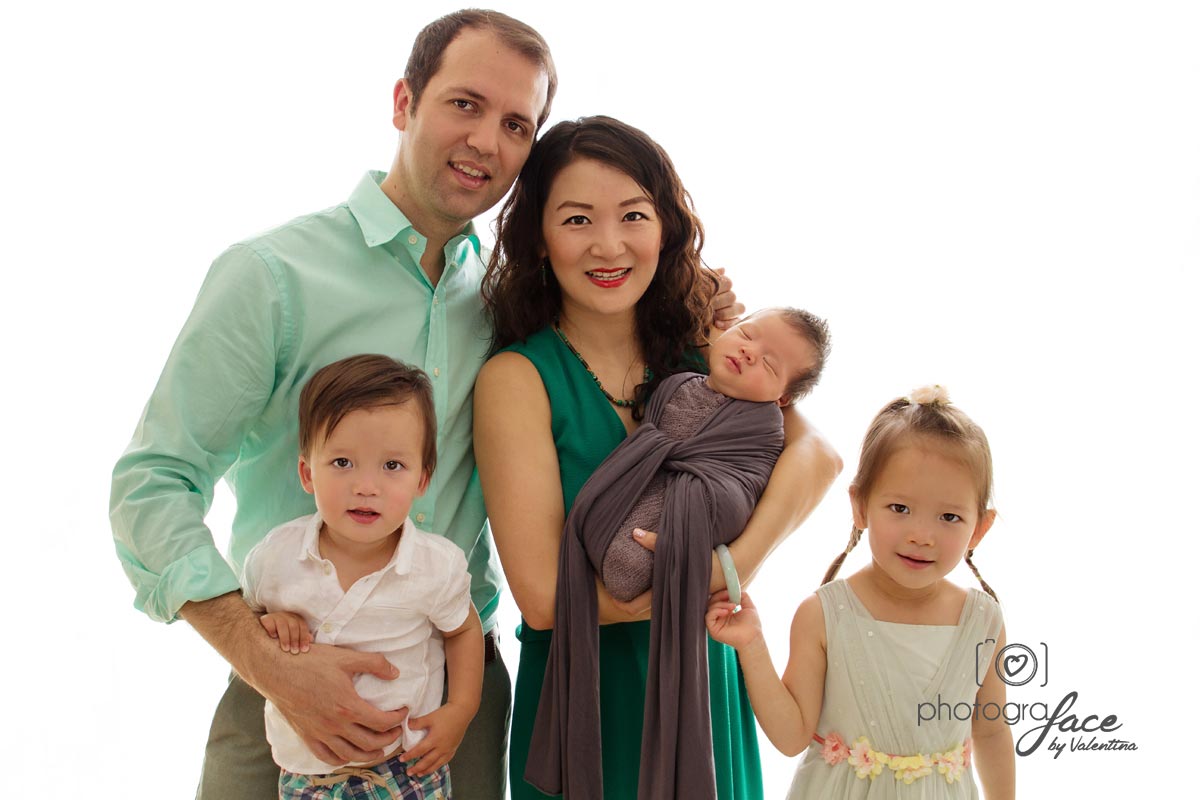 Family portrait: mum is holding new baby. Dad and siblings are around her