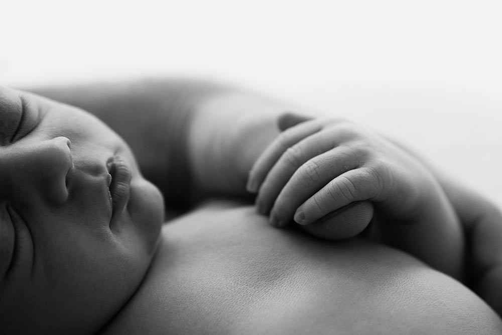 Close-up of newborn baby's tiny hand and fingers during a baby-led photography session in London.