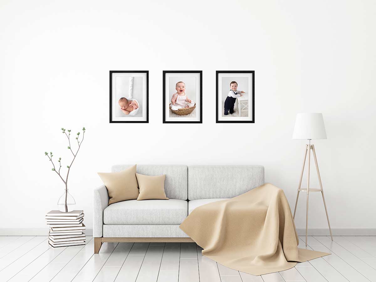 living room with 3 frames displaying baby and newborn photography
