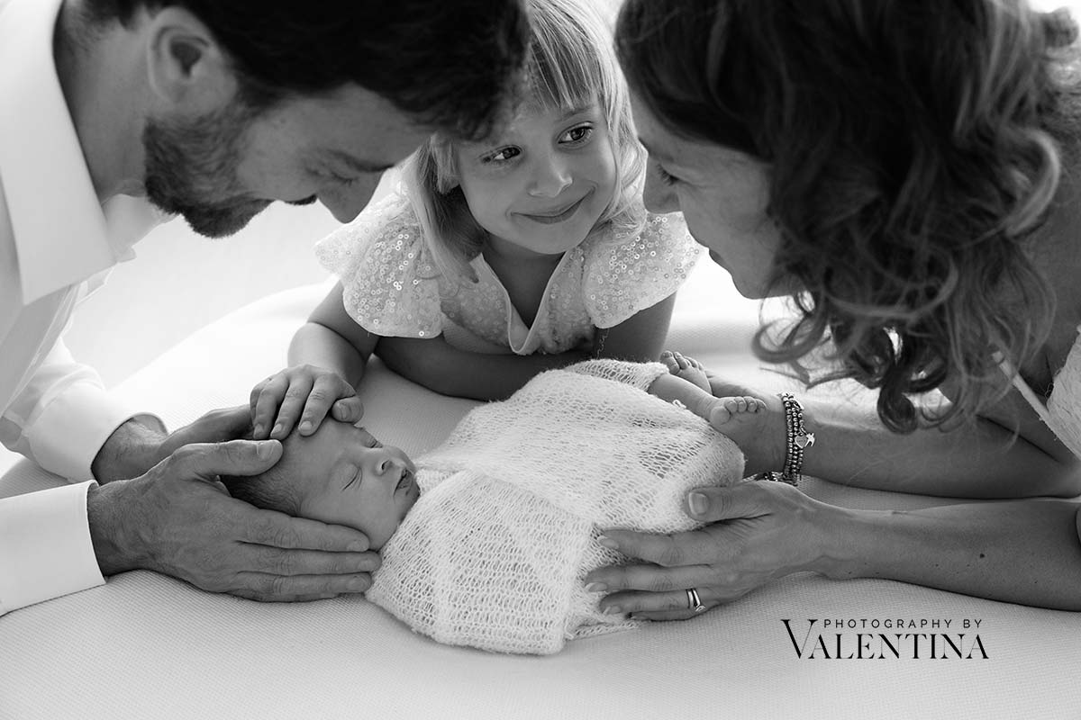 newborn boy swaddled while held by parents during a London newborn photo session